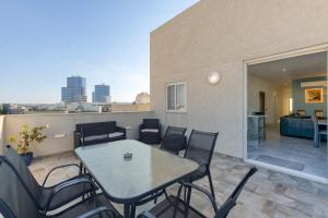 a patio with a table and chairs on a balcony at Annitchka Mansions - Penthouse in central Malta in Birkirkara