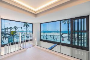 a room with windows and a view of the beach at Apartamentos Playa Victoria in Cádiz