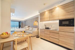 cocina y sala de estar con mesa y sofá en Apartamentos Playa Victoria, en Cádiz