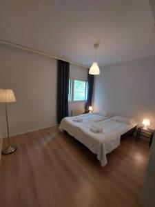 ein Schlafzimmer mit einem großen Bett und einem Fenster in der Unterkunft Kotimaailma - Tilava 2MH asunto saunalla Herttoniemen merellisessä ympäristössä in Helsinki