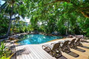 a swimming pool with lounge chairs and trees at POINCIANA 101 HAMILTON ISLAND CENTRALLY LOCATED 3 BEDROOM, plus BUGGY!! in Hamilton Island
