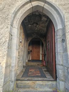 een boog in een gebouw met een houten deur bij Ballindooley Castle in Galway