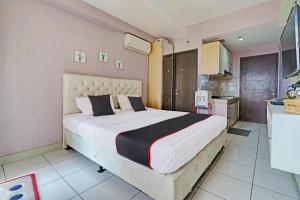 een slaapkamer met een groot bed en een keuken bij OYO Life 92548 M-square Apartment By Lins Pro in Bandung