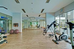 einen Fitnessraum mit Laufbändern und Trainingsgeräten in einem Gebäude in der Unterkunft OYO Life 92548 M-square Apartment By Lins Pro in Bandung