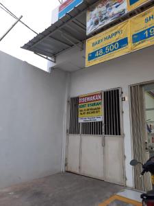 uma garagem com um sinal para uma farmácia Disney em OYO Life 92781 Kost Parung Serab Syariah em Tangerang