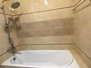 a white tub in a bathroom with a shower at Luxe Apartments on Stepnoy in Karagandy +11 photos