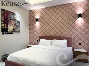 - une chambre avec un lit blanc et un mur rose dans l'établissement Kease King Salman K-1 Lusso Najd AZ89, à Riyad