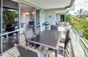a dining room with a table and chairs on a balcony at POINCIANA 101 HAMILTON ISLAND CENTRALLY LOCATED 3 BEDROOM, plus BUGGY!! in Hamilton Island