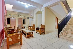a living room with wooden furniture and a staircase at OYO Life 92663 Karmel 6 in Purwokerto