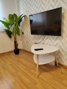 a living room with a white table and a tv at Urbanlux Hospital II in Albacete