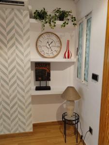 a room with a clock on the wall and a table at Urbanlux Hospital II in Albacete