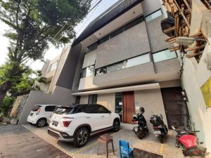 een witte SUV geparkeerd voor een huis bij OYO Life 92770 Cozy Puri 22 in Jakarta