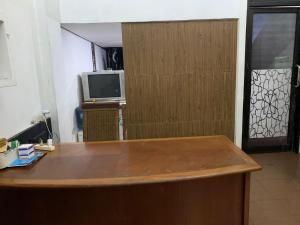 een kamer met een bureau, een deur en een televisie bij OYO Life 92770 Cozy Puri 22 in Jakarta