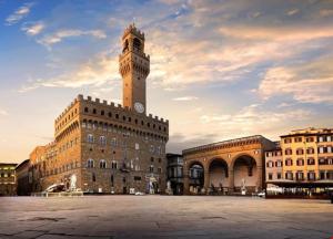 a building with a clock tower on top of it at Room114 - Studio apartment near the center in Florence