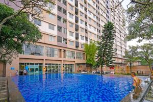 a large blue pool in front of a building at OYO Life 92774 The Edge Apartment By My Home in Cimahi