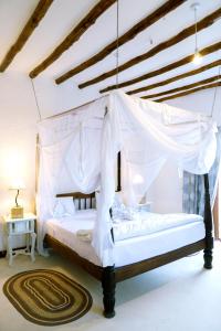 a bedroom with a canopy bed with a rug at Met Beach Resort Malindi in Malindi
