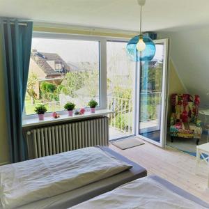 a bedroom with a bed and a large window at Dein Ferienhaus Strandstrasse in Fehmarn