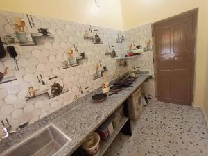 a kitchen with a sink and a counter top at Dey Niwas in Dum Dum