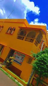 um edifício amarelo com janelas e uma árvore em frente em Dey Niwas em Dum Dum