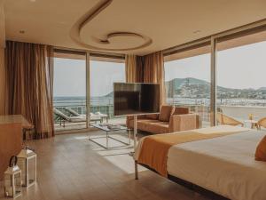 een hotelkamer met een bed en een flatscreen-tv bij Aguas de Ibiza Grand Luxe Hotel - Small Luxury Hotel of the World in Santa Eularia des Riu