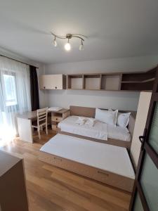 um quarto com uma cama, uma secretária e uma mesa em Urban George Enescu 4 BeedRoom Apartment Suceava em Suceava