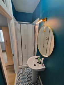 a bathroom with a shower and a sink and a mirror at Modern 4 Bedroom Townhouse in City Centre in Dublin