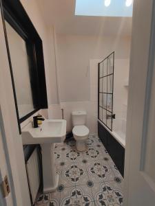 a white bathroom with a sink and a toilet at Modern 4 Bedroom Townhouse in City Centre in Dublin