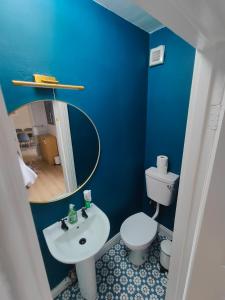 Baño azul con lavabo y aseo en Modern 4 Bedroom Townhouse in City Centre, en Dublín