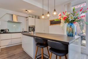 a kitchen with a counter with a vase of flowers at Kerkakker0 Luxery apartment with garden in the city center in Eindhoven