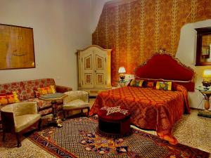 a bedroom with a red bed and a couch at Locanda Cà Del Console in Venice
