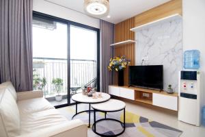 a living room with a white couch and a tv at QMP - Vinhomes Ocean Park in Hanoi