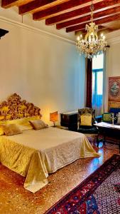 ein großes Schlafzimmer mit einem großen Bett und einem Kronleuchter in der Unterkunft Locanda Cà Del Console in Venedig