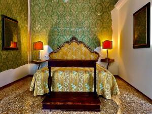 a bed in a bedroom with green wallpaper at Locanda Cà Del Console in Venice