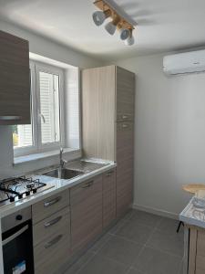 uma cozinha com armários de madeira e um lavatório em P.house2023 em Torre del Greco