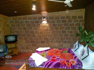 a bed with a purple blanket with flowers on it at The Dream in SanivÄrsante
