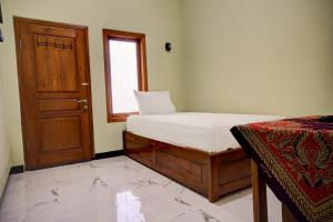 A bed or beds in a room at OYO Life 92922 Kost Bu Mala 1 Syariah