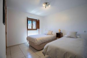 um quarto com 2 camas e uma janela em Casa Feli - APARTAMENTO con JARDÍN PRIVADO en los PIRINEOS em Castiello de Jaca