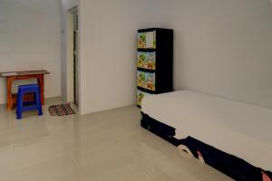 um quarto com uma cama, uma mesa e um banco em OYO Life 92918 Rumah Kost Arrahma Syariah em Nganjuk