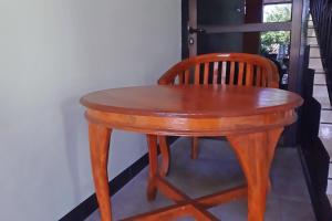 a wooden table and chair next to a window at OYO Life 92915 Duta Amnan Syariah in Sidoarjo