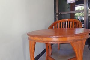 a wooden table and chair sitting next to a door at OYO Life 92915 Duta Amnan Syariah in Sidoarjo