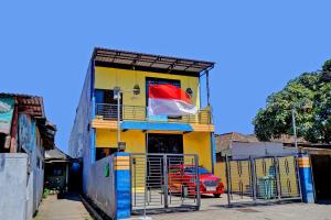 a yellow building with a flag on a balcony at OYO Life 92915 Duta Amnan Syariah in Sidoarjo