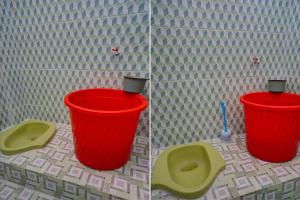 baño con 2 cubos rojos y aseo en OYO Life 92918 Rumah Kost Arrahma Syariah en Nganjuk