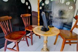 uma mesa com duas cadeiras e uma televisão em OYO Life 92918 Rumah Kost Arrahma Syariah em Nganjuk