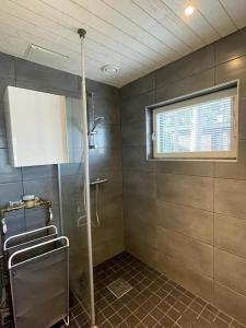 baño con cabina de ducha y ventana en Rantahuvila Naantalissa, en Naantali