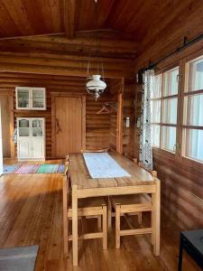 a wooden dining room with a table in a cabin at Rantahuvila Naantalissa in Naantali