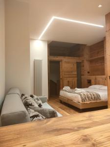 a bedroom with two beds and a couch at Fior di Roccia Apartments in Breuil-Cervinia