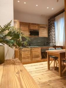 a kitchen with wooden cabinets and a wooden table at Fior di Roccia Apartments in Breuil-Cervinia