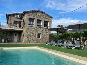 une villa avec une piscine en face d'une maison dans l'établissement Ca la Joia Casa con piscina privada en la Vall d'en Bas, à Les Preses