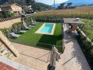 - une vue sur une cour avec une piscine et une pelouse dans l'établissement Ca la Joia Casa con piscina privada en la Vall d'en Bas, à Les Preses