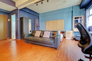 ein Wohnzimmer mit Sofa und blauen Wänden in der Unterkunft OYO Life 92984 The Suites Metro Apartement By Echie Property in Bandung